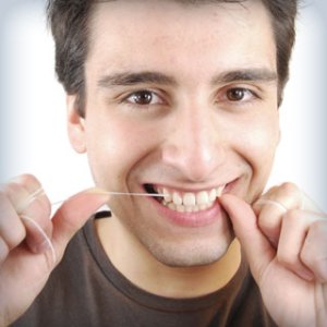 man flossing his teeth